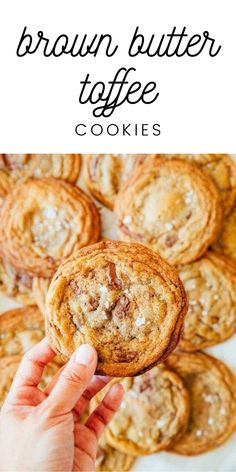 a hand holding up a chocolate chip cookie with the words brown butter toffe cookies above it