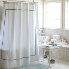 a bath room with a shower curtain and a rug on the floor in front of it