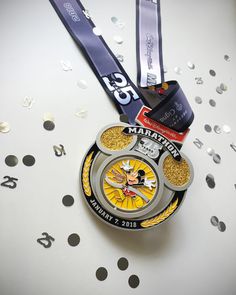 a medal with mickey mouse on it sitting next to confetti