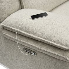 an electronic device is plugged in to the back of a reclining couch with two pillows