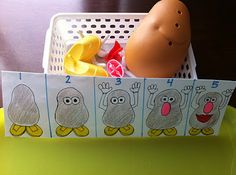 an egg is sitting in a basket next to other toys on a yellow tablecloth