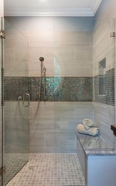 a walk in shower sitting next to a glass door and tiled floored bathroom area