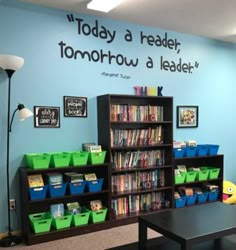 a library with bookshelves and bins filled with children's toys in front of a sign that reads today a reader tomorrow a leader, tomorrow a leader