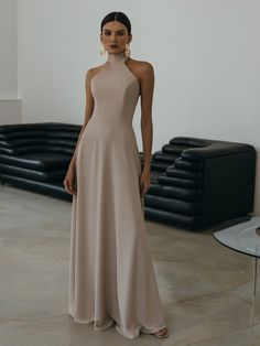 This elegant head-turning dress is tailored from smooth fabric in a figure-skimming silhouette. Defined by an alluring bodice with a halterneck it flows to a stunning flared maxi hem. The dress beautifully showcases an open back and features long ribbon ties at the back of the neck for an elevated finish.- maxi-length hem- slightly close fit- halterneck with long ties at the back- open back- flared hem- concealed zip fastening at the back Beige Long Dress Formal, Beige Long Dresses, High Neck Long Dress, Head Turning Dress, Silk Party Dress, Minimal Dress, Sheer Midi Dress, Online Fashion Store, Satin Maxi