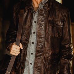 Inspired by the old west ranchers who made their mark at the base of the Bighorns… the Sheridan Barn Coat delivers enduring quality worthy of the pioneers of the past, tailored with a modern fit for the present. Outfitted with 100% full-grain lambskin leather, the Sheridan is secured by a top-to-bottom zipper concealed beneath distressed antique brass buttons, shielding an easy-clean lining that offers ample comfort and utility from sunup to sundown. Twin button-flap pockets at the side and one Waxed Canvas Jacket, Dark Brown Leather Jacket, Barn Coat, Barn Jacket, The Old West, Brass Buttons, Lambskin Leather Jacket, Leather Jacket Style, Leather Duffle Bag