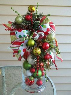 a glass vase filled with ornaments on top of a table