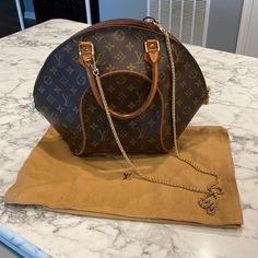 Excellent Condition. Unique Structured Design. Hand Bag Or Crossbody. Authentic Dust Bag Included. Generic Gold Chain Included. One Strap Side Restitched. Authentic Lock And Key Included. Louis Vuitton Ellipse, Bags Louis Vuitton, Structured Design, Lock And Key, Louis Vuitton Bags, Hand Bag, Gold Chain, Gold Chains, Dust Bag