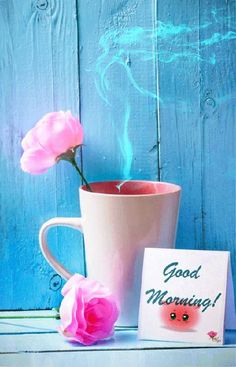 a pink coffee cup with a flower in it next to a card that says good morning