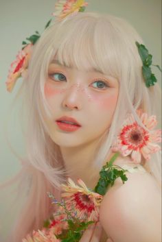 a woman with blonde hair and flowers in her hair is posing for the camera,