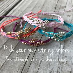 four different colored bracelets with gold beads on them and the words pick your own string colors