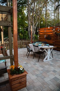 an outdoor dining area with table and chairs