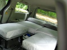 there are two beds in the back of an suv with no mattresses on it