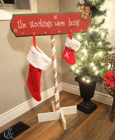 a christmas tree with stockings hanging from it's poles and a sign that says the stockings were hung