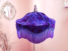 a purple hat on a stand in front of a pink wall