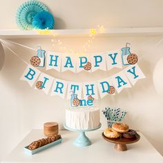 a happy birthday banner with cookies and doughnuts on it next to a cake