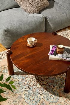 a coffee table with two cups on it in the middle of a living room area