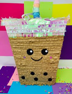 a basket with a face painted on it and confetti in the top corner