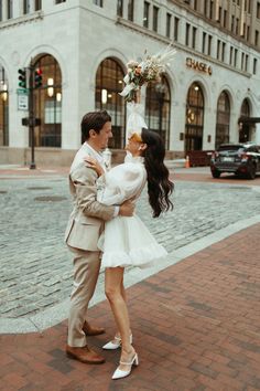 a man and woman standing next to each other in front of a building