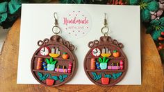 the earrings are made out of wood and have colorful decorations on them, including flowers