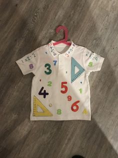 a child's white shirt with numbers on it