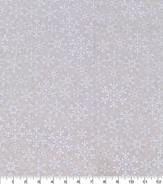 a white fabric with snowflakes on it and a ruler in the foreground