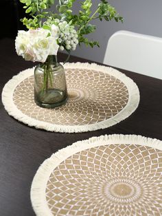 two vases filled with flowers on top of a wooden table