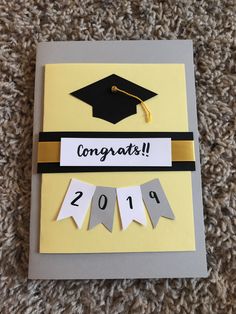 congratulations card with graduation cap and ribbon on carpeted area in front of carpeting