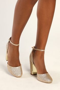 a close up of a person wearing gold glitter high heeled shoes with ankle straps