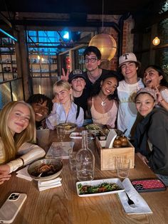 a group of people sitting around a wooden table