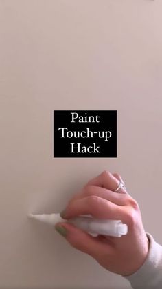 a woman's hand holding a paint touch - up hack