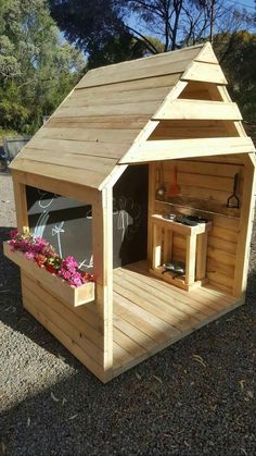 a small wooden shed with flowers in it