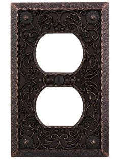 an ornate iron outlet cover with a decorative design