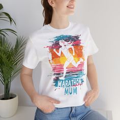 Celebrate the unstoppable spirit of marathon-running mums with our exclusive Marathon Mum Graphic T-Shirt. Crafted from premium quality cotton, this t-shirt provides a soft and comfortable fit, perfect for everyday wear. The design features a vibrant and dynamic graphic of a female runner set against a sunset-inspired backdrop, capturing the essence of determination and strength. This t-shirt is more than just a piece of clothing; it's a tribute to all the marathon mums out there who balance lif Cotton Short Sleeve T-shirt For Running, White Graphic Print T-shirt For Running, Sporty Graphic Print T-shirt For Marathon, White Sporty Tops For Marathon, Female Runner, Marathon Runner, The Marathon, Running Gifts, Marathons