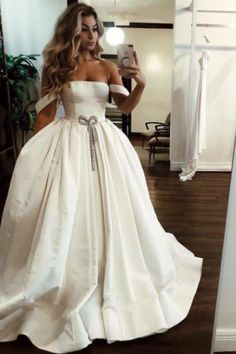 a woman is taking a selfie in her wedding dress while wearing a white gown