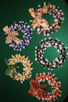 several bracelets are laid out on a green surface with bows and ribbons around them