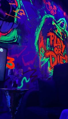 a tv sitting on top of a table in front of a wall covered with graffiti