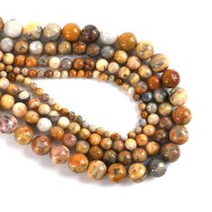 a strand of multicolored agate beads on a white background with the letter s in the middle