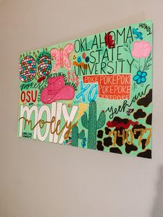 a painting on the wall that has words and pictures all over it in different colors