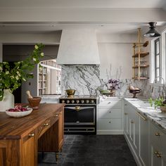 a kitchen with marble counter tops and white cabinets, along with an island in the middle