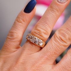 a close up of a person's hand with a ring on their finger and two diamonds in the middle