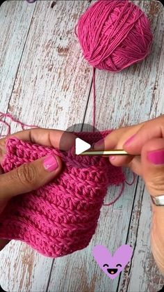 someone is knitting yarn with a crochet hook in the middle and another hand holding a ball of yarn