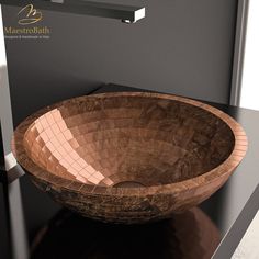 a wooden bowl shaped sink sitting on top of a black counter next to a mirror