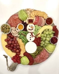 a platter filled with grapes, apples, grapes, cheese and other food items