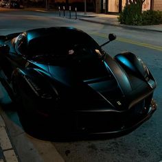 the black sports car is parked on the side of the street