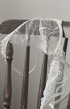 an old chair with white lace on it