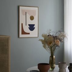 a vase filled with flowers sitting on top of a white table next to a window