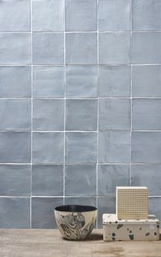 an old radio sitting on top of a wooden table next to a blue tiled wall