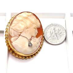 "14k Yellow Gold Cameo Diamond Brooch pendant Beautiful detailed carving on her hair and flowers on her dress Clasp and pendant hoop in good working condition Stamped: \"14k\" inside of the rim Measures approx. 1 1/2\" long X 1 1/4\" wide or 3.9 cm X 3 cm Outside rim measures approx. 2 mm wide - Twisted rope Diamond is approx: .02 ct Total weight: 8.1 g 041315-4070 FEEL FREE TO MESSAGE ME IF YOU HAVE ANY QUESTIONS OR WISH TO SEE MORE PICTURES * Back to Shop Watch and Wares? https://www.etsy.com/ Carved Yellow Gold Brooches For Wedding, Elegant Carved Gold Brooches, Elegant Carved Brooches For Gifts, Yellow Gold Intaglio Jewelry, Oval Brooches For Formal Occasions, Carved Brooches For Formal Occasions, Yellow Gold Brooches For Anniversary, Exquisite Brooches For Wedding, Exquisite Collectible Jewelry Brooch