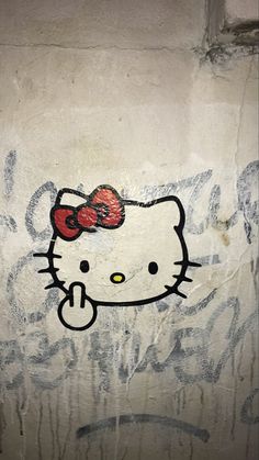 an image of a hello kitty painted on the side of a building with red bow