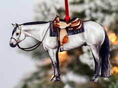 a horse ornament hanging from a christmas tree